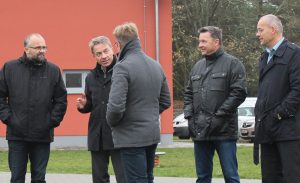 Mehrere Personen vor einem roten Gebäude