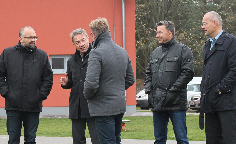 Mehrere Personen vor einem roten Gebäude