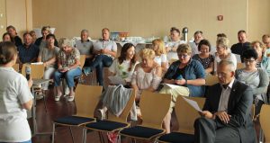 Mehrere sitzende Personen in einem Saal