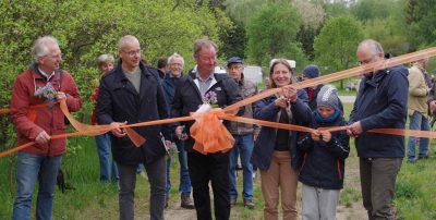Mehrere Personen zerschneiden symbolisch ein Eröffnungsband.
