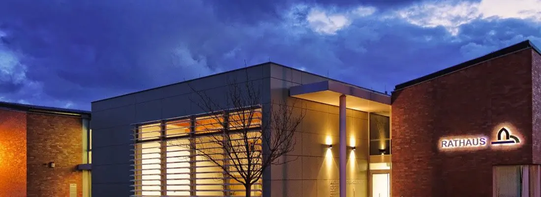 Rathaus Britz beleuchtet bei blauer Stunde.