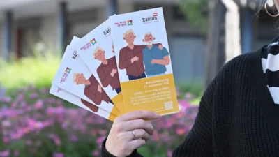 Eine Person hält Broschüren in ihrer Hand.