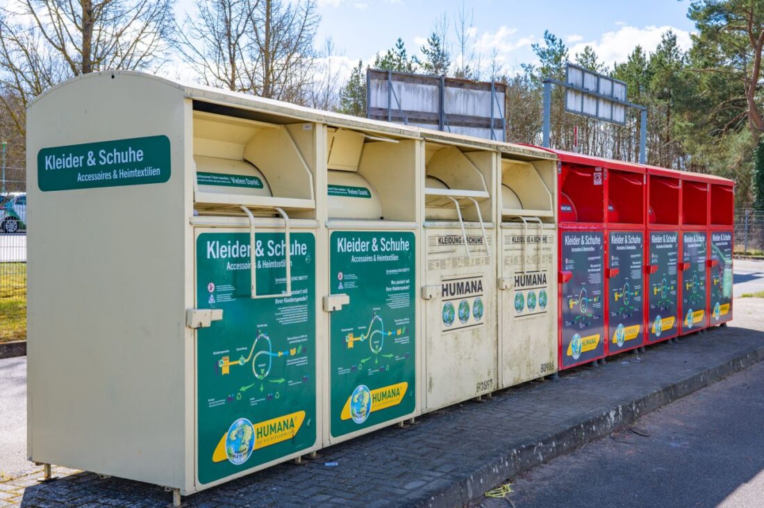 Mehrere nebeneinander aufgestellte Altkleidercontainer.