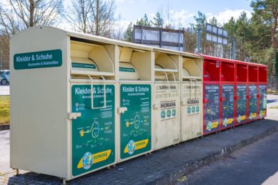 Mehrere nebeneinander aufgestellte Altkleidercontainer.