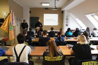 Menschen von der Feuerwehr in einem Seminarraum