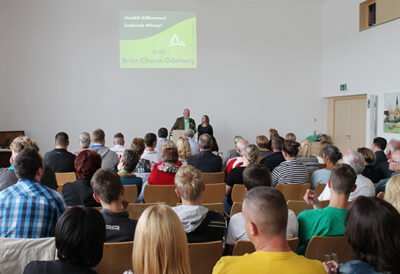 Viele Menschen sitzen in einem Saal.