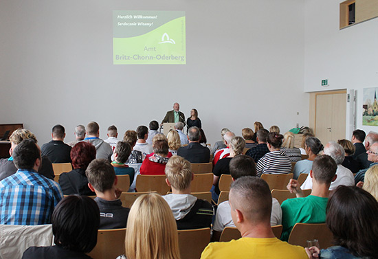 Viele Menschen sitzen in einem Saal.