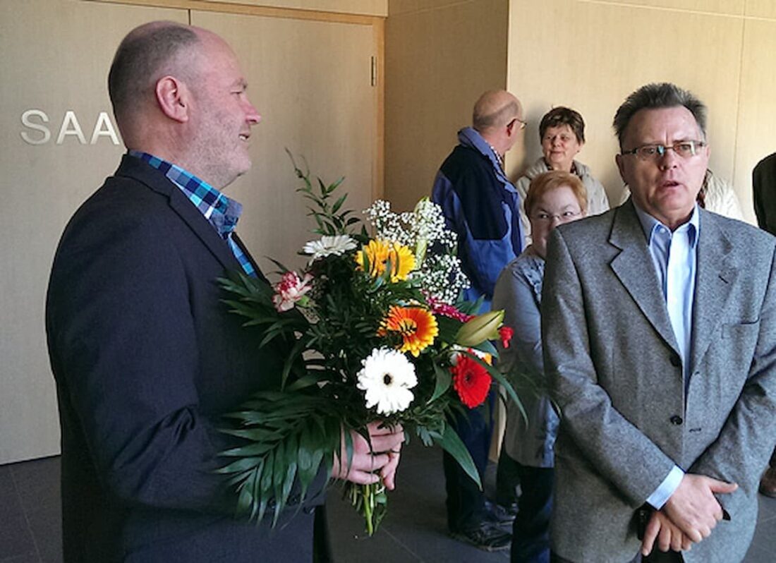 Eine Person überreicht einer anderen Person einen Blumenstrauß.