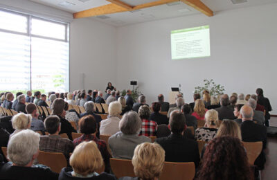 Viele Personen sitzen in einem Saal
