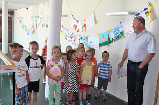 Kinder vor einer Wand mit gemalten Bildern