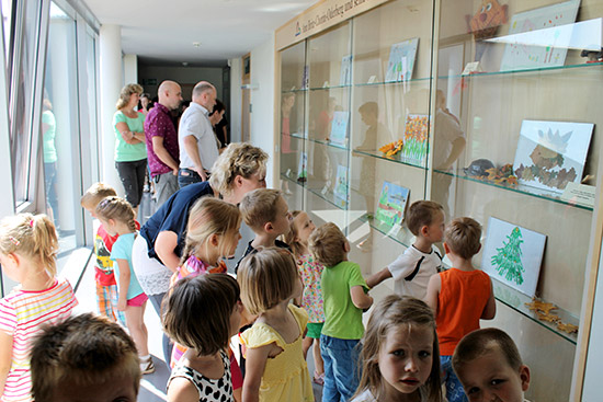 Kinder vor einer Wand mit gemalten Bildern