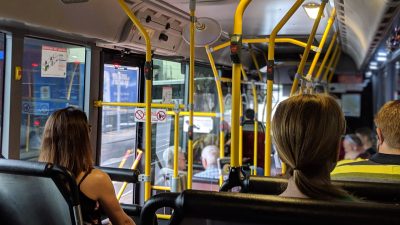 Innenraum eines Linienbusses mit mehreren Passagieren.