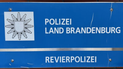 Blaues Schild mit Logo der Polizei und dem Text Polizei Land Brandenburg, Revierpolizei.