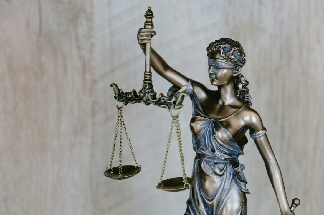 Büste der Justitia mit Waagschalen.